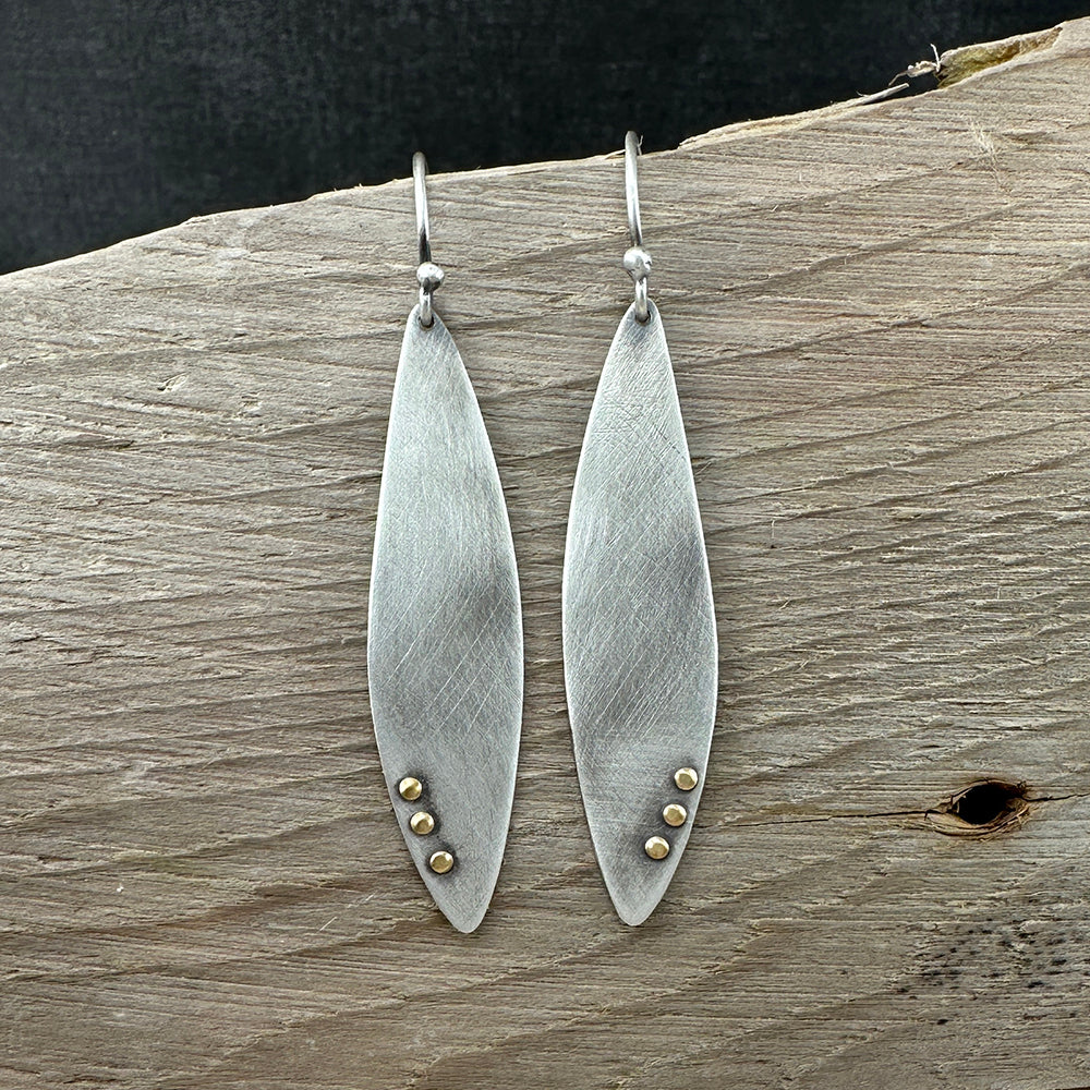 Sterling Silver wing shaped dangle earrings with a brushed finish and brass rivet details all with a patina