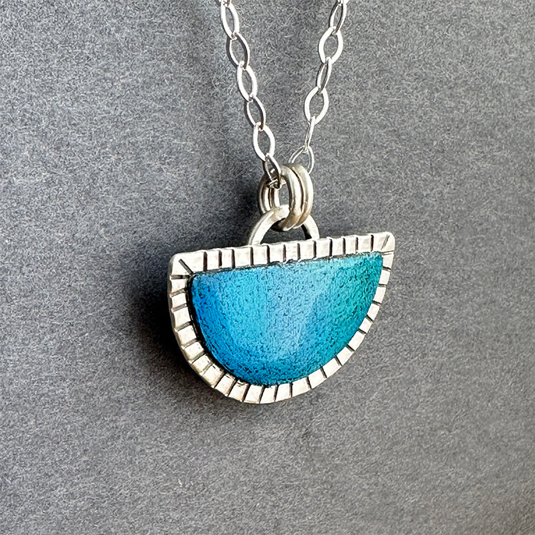 Hand crafted half round sterling silver pendant with hand colored blues sealed with resin for shine and durability.