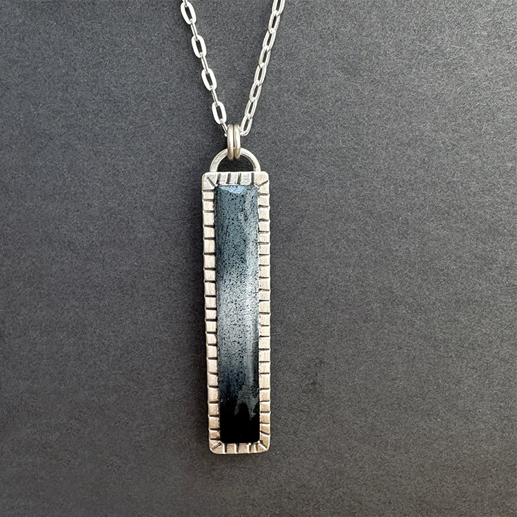 Narrow sterling silver pendant with hand colored grayscale design